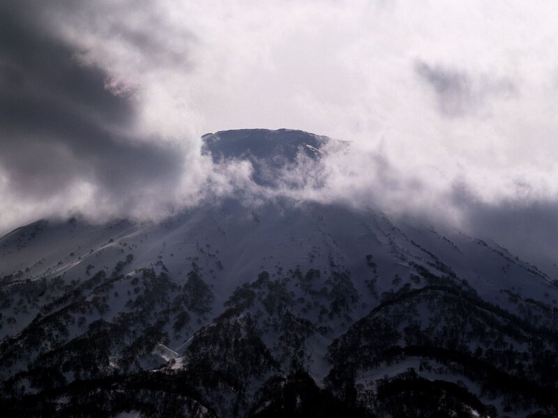 Snowy mountain peak under clouds