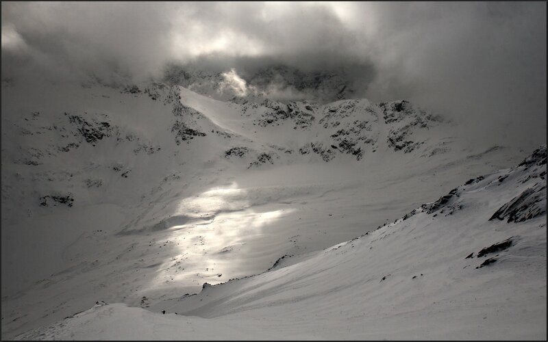 Snowy mountain peak under clouds