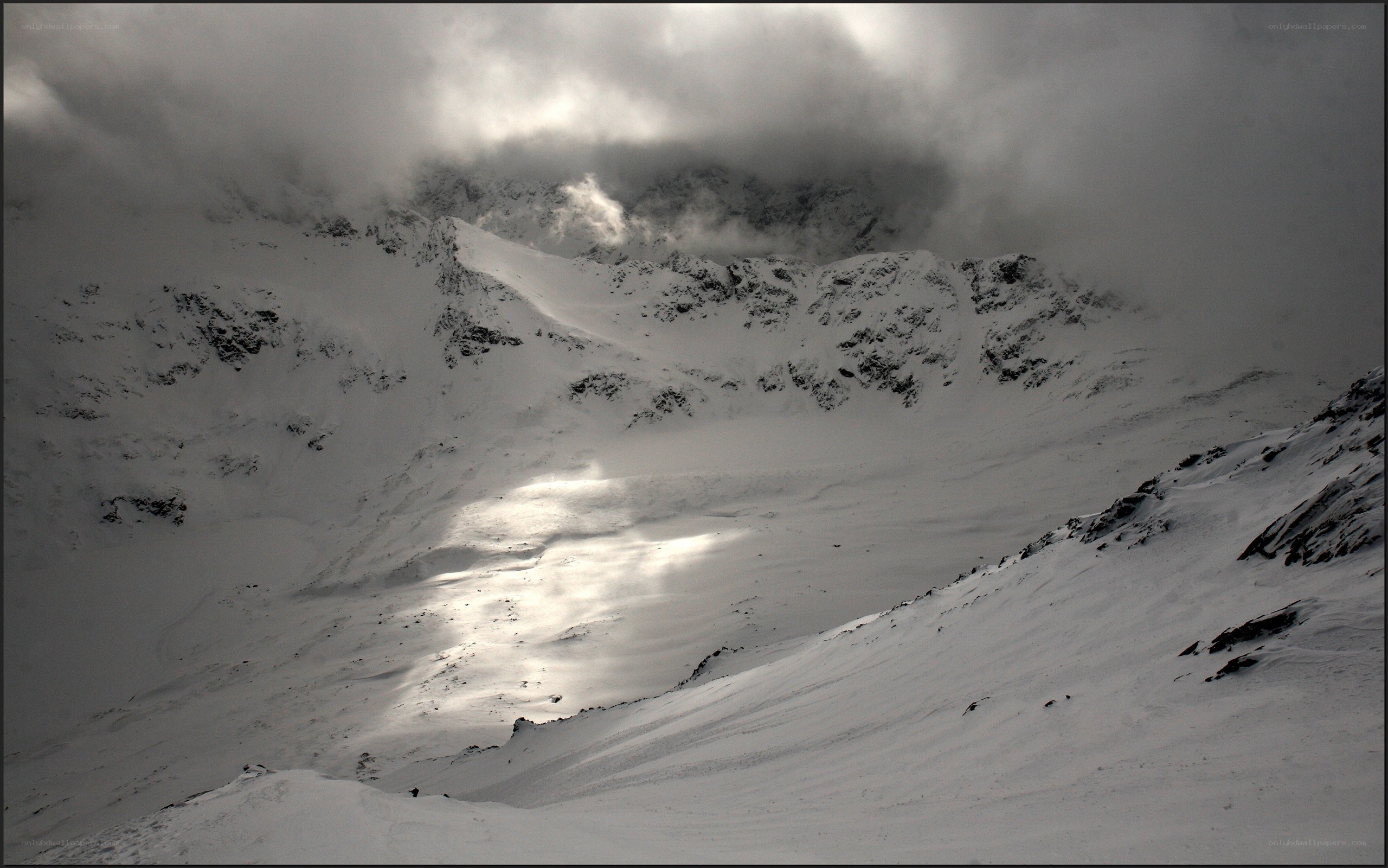 Snowy mountain peak under clouds
