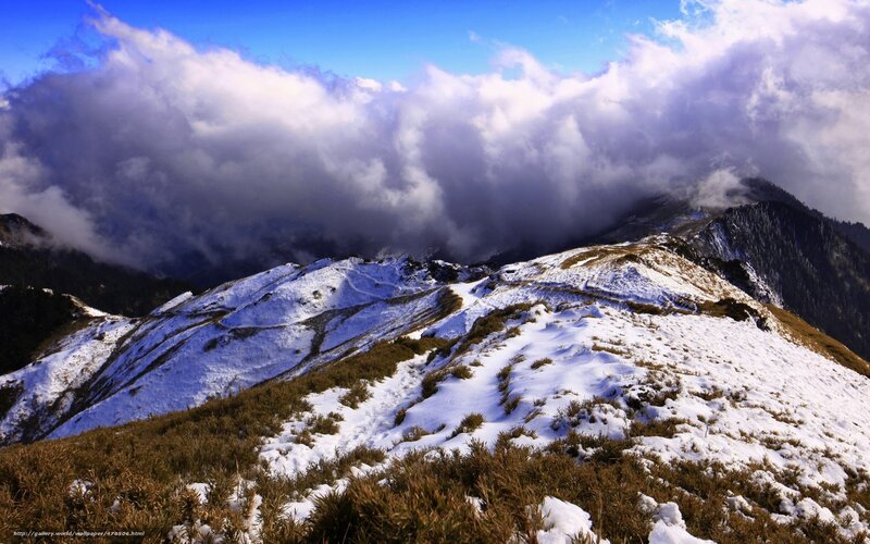 Snowy mountain peak under clouds