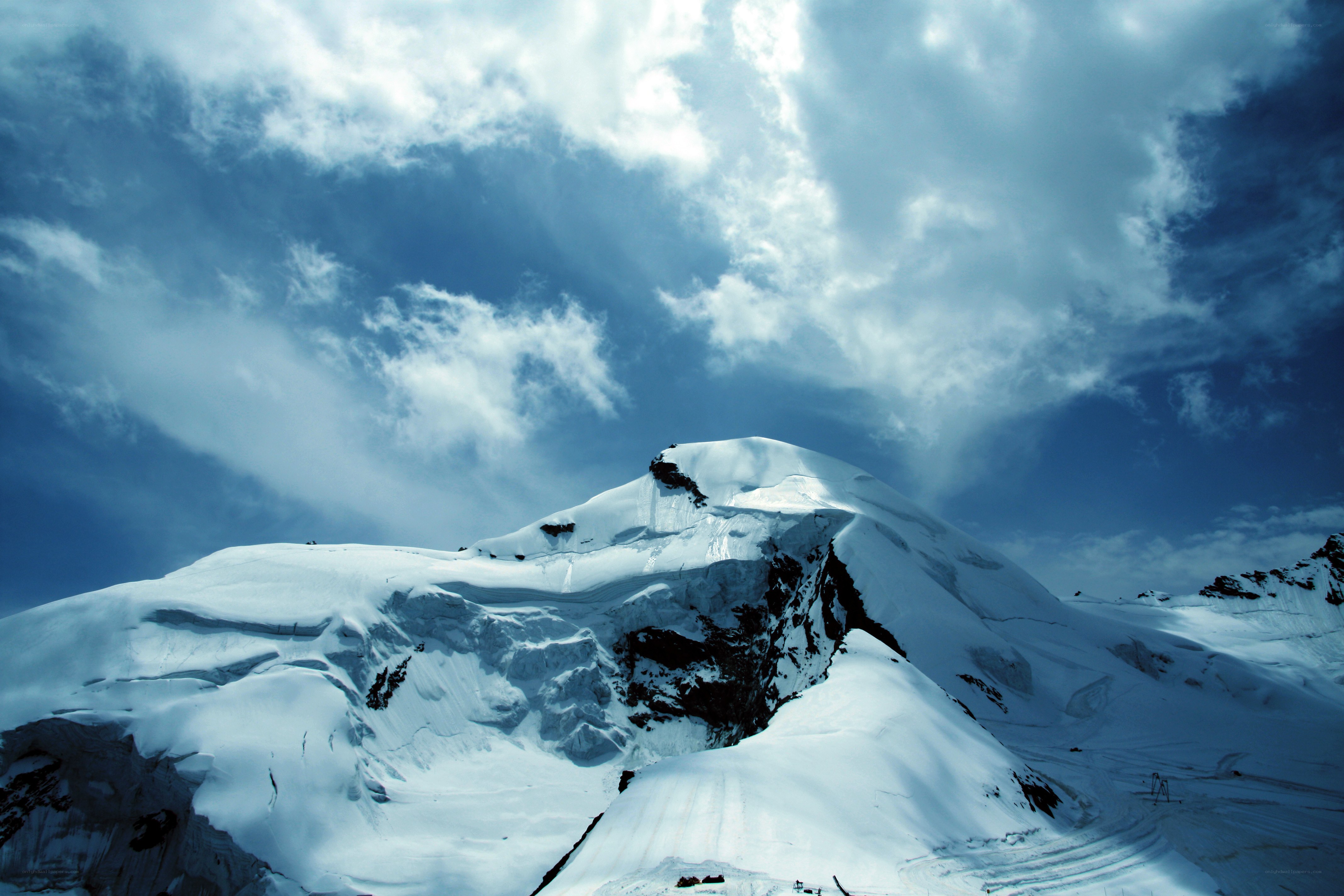 Snowy mountain peak under cloudy sky