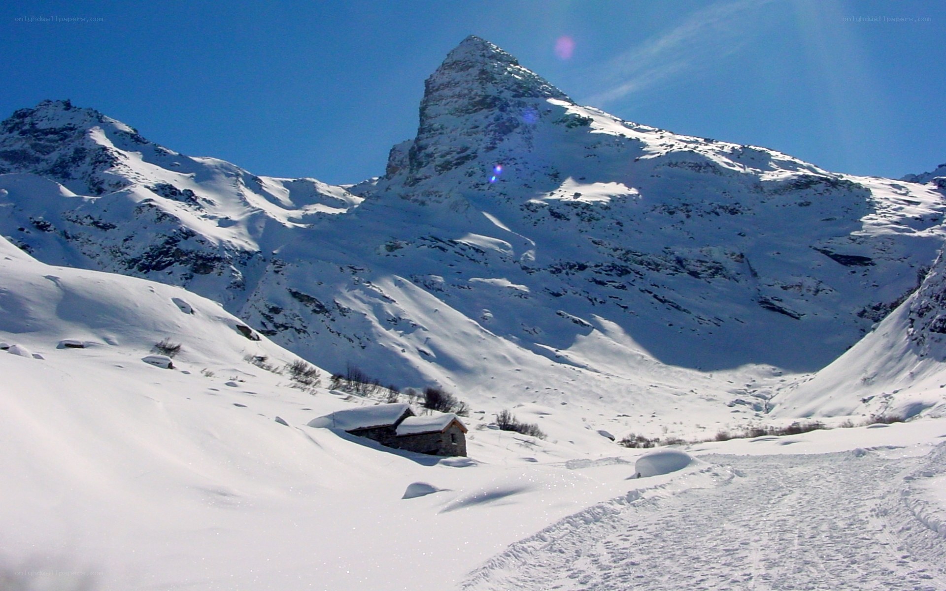 Snowy mountain peak with cabin