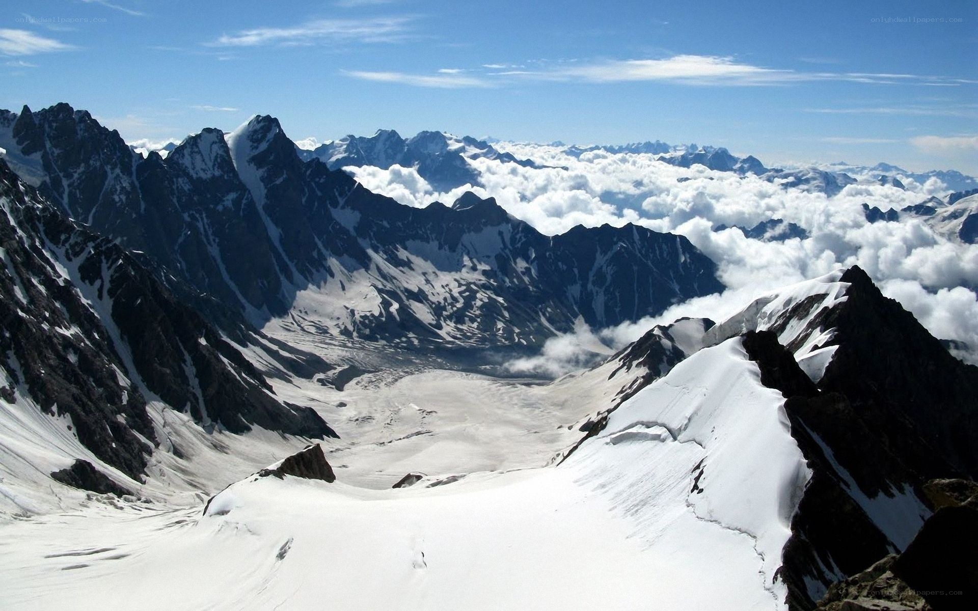 snowy mountain peaks above clouds