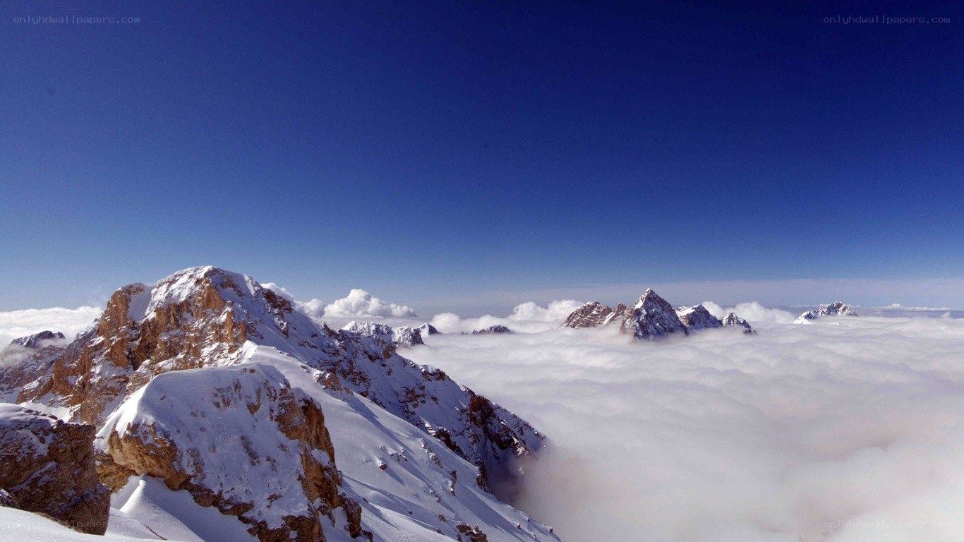 snowy mountain peaks above clouds