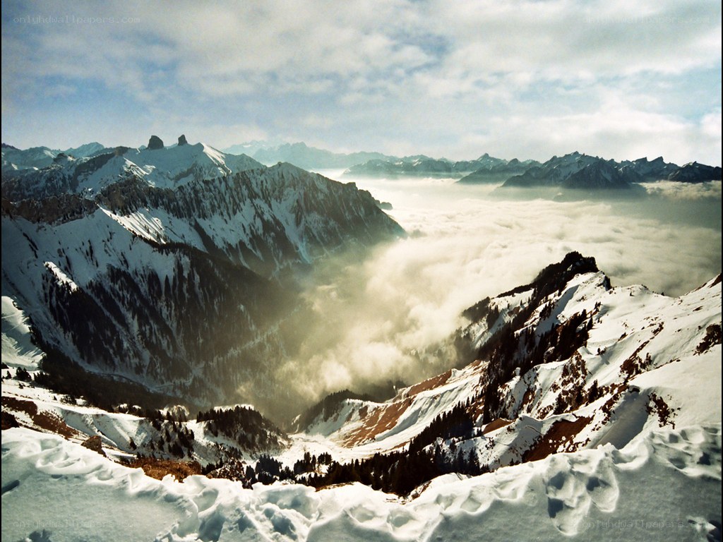 Snowy mountain peaks above clouds