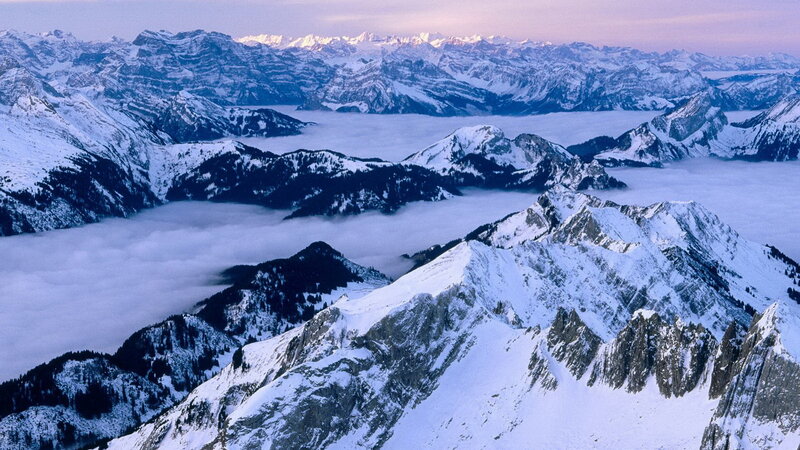 Snowy mountain peaks above clouds