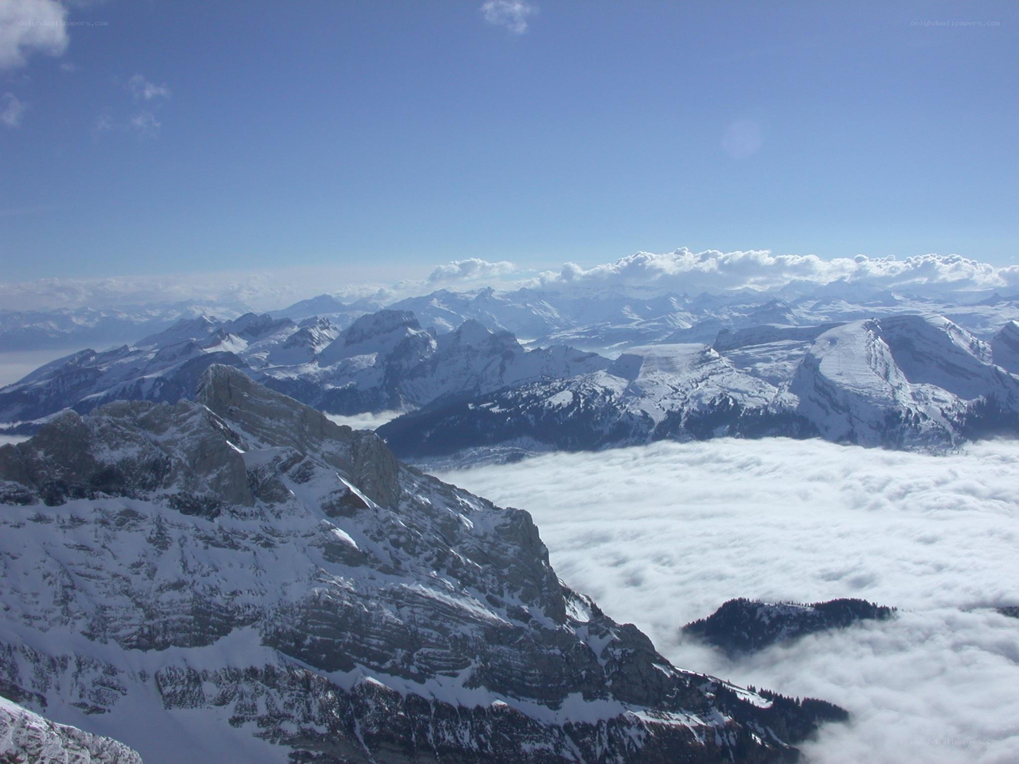 Snowy mountain peaks above clouds