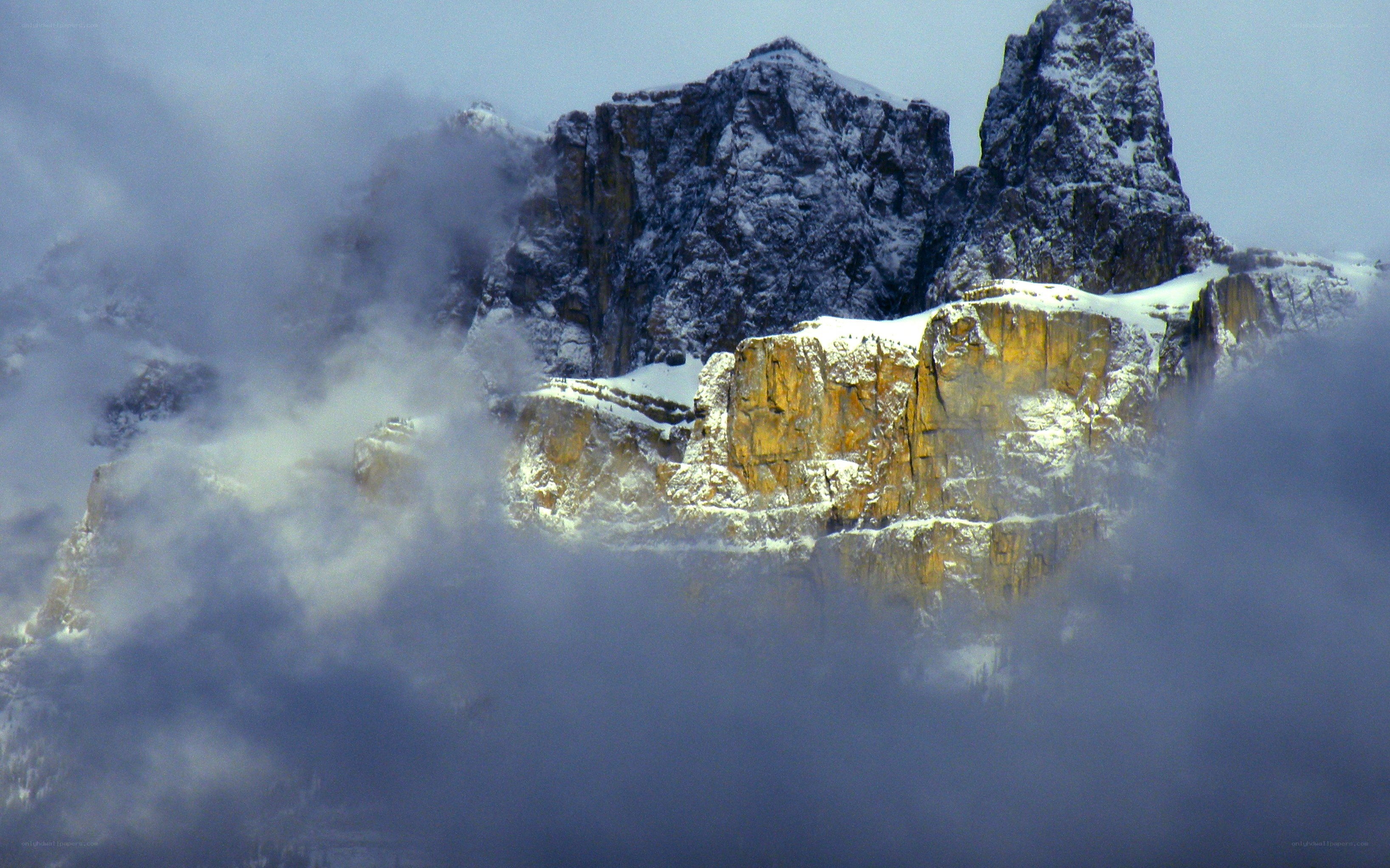 Snowy mountain peaks in clouds