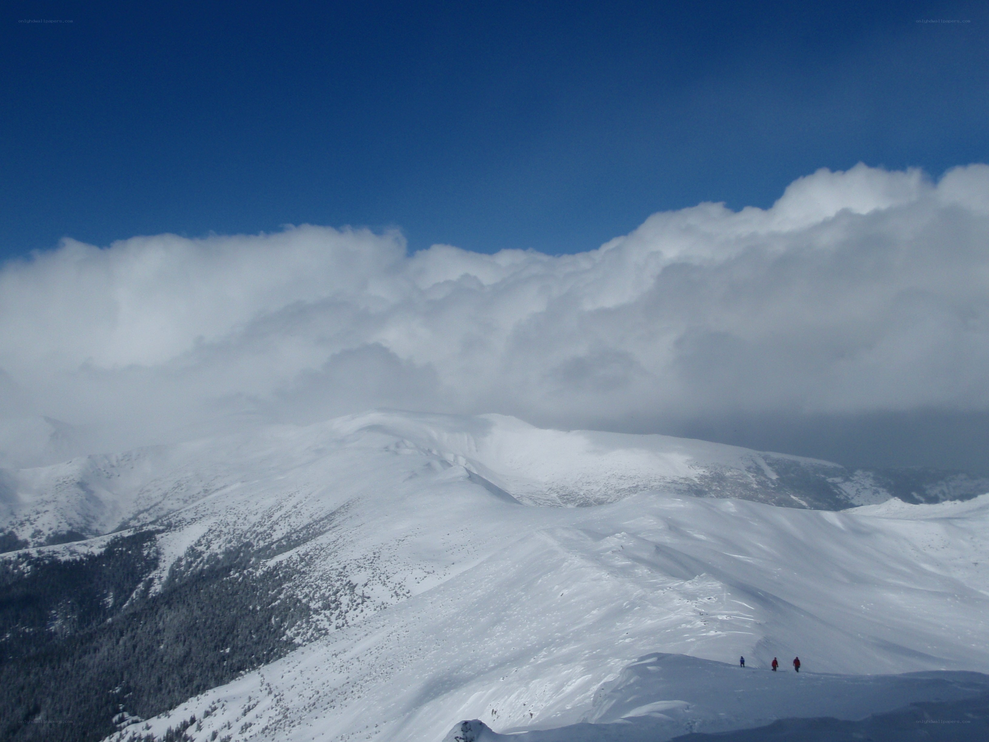 Snowy mountain peaks under clouds