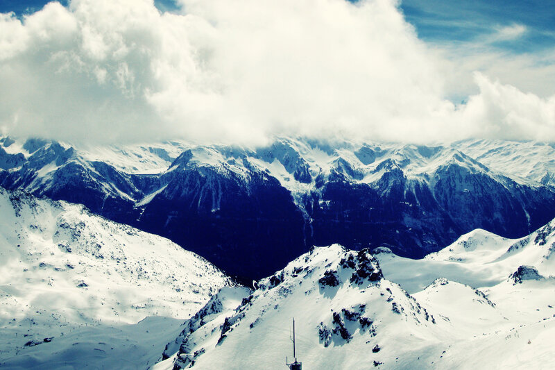 snowy mountain peaks under clouds