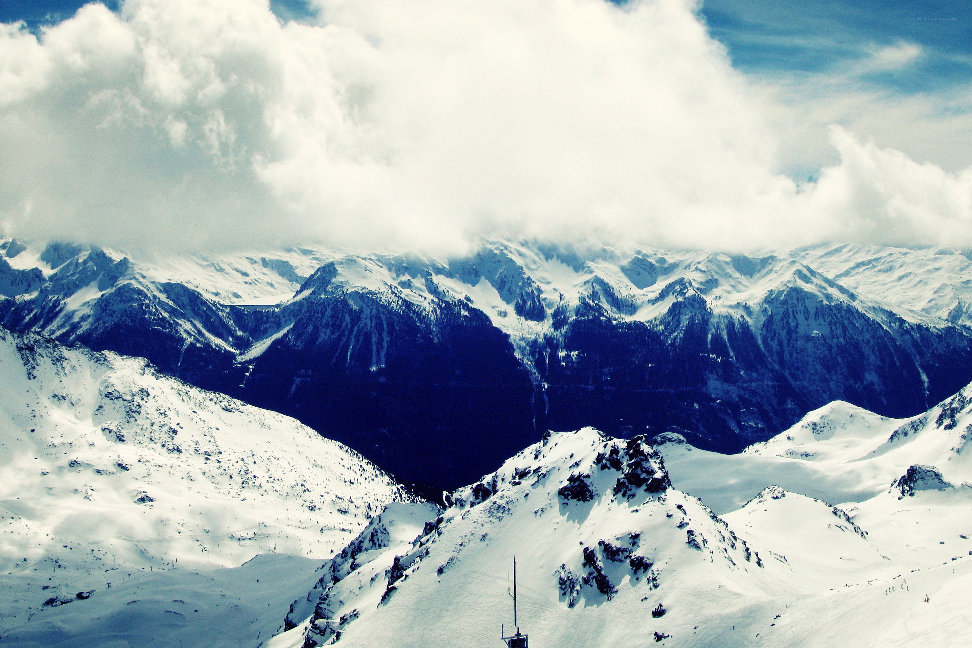 snowy mountain peaks under clouds