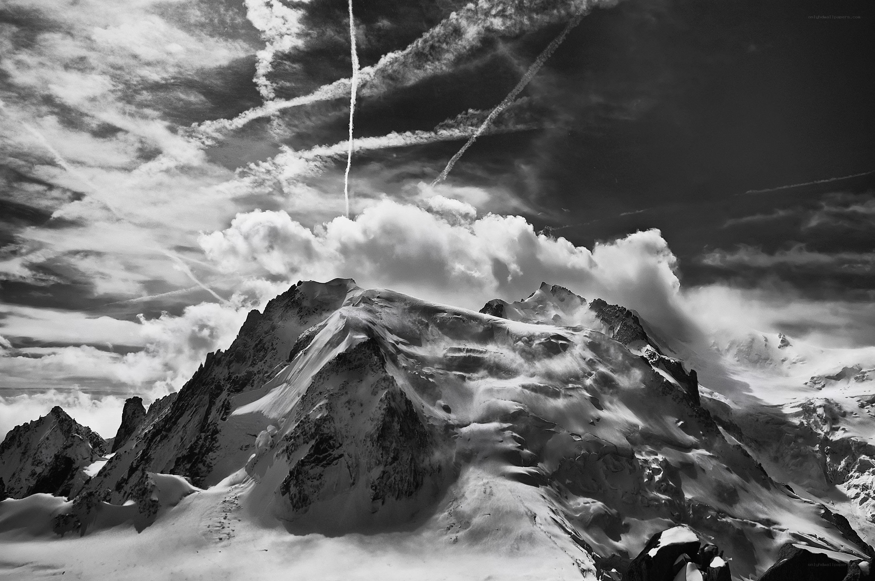 Snowy mountain peaks under cloudy sky