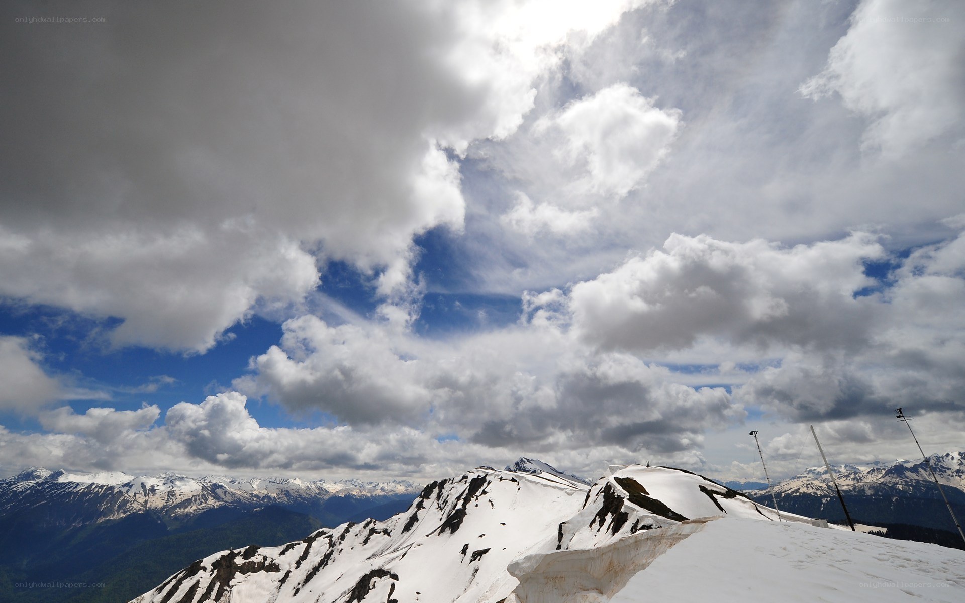 Snowy mountain peaks under cloudy sky