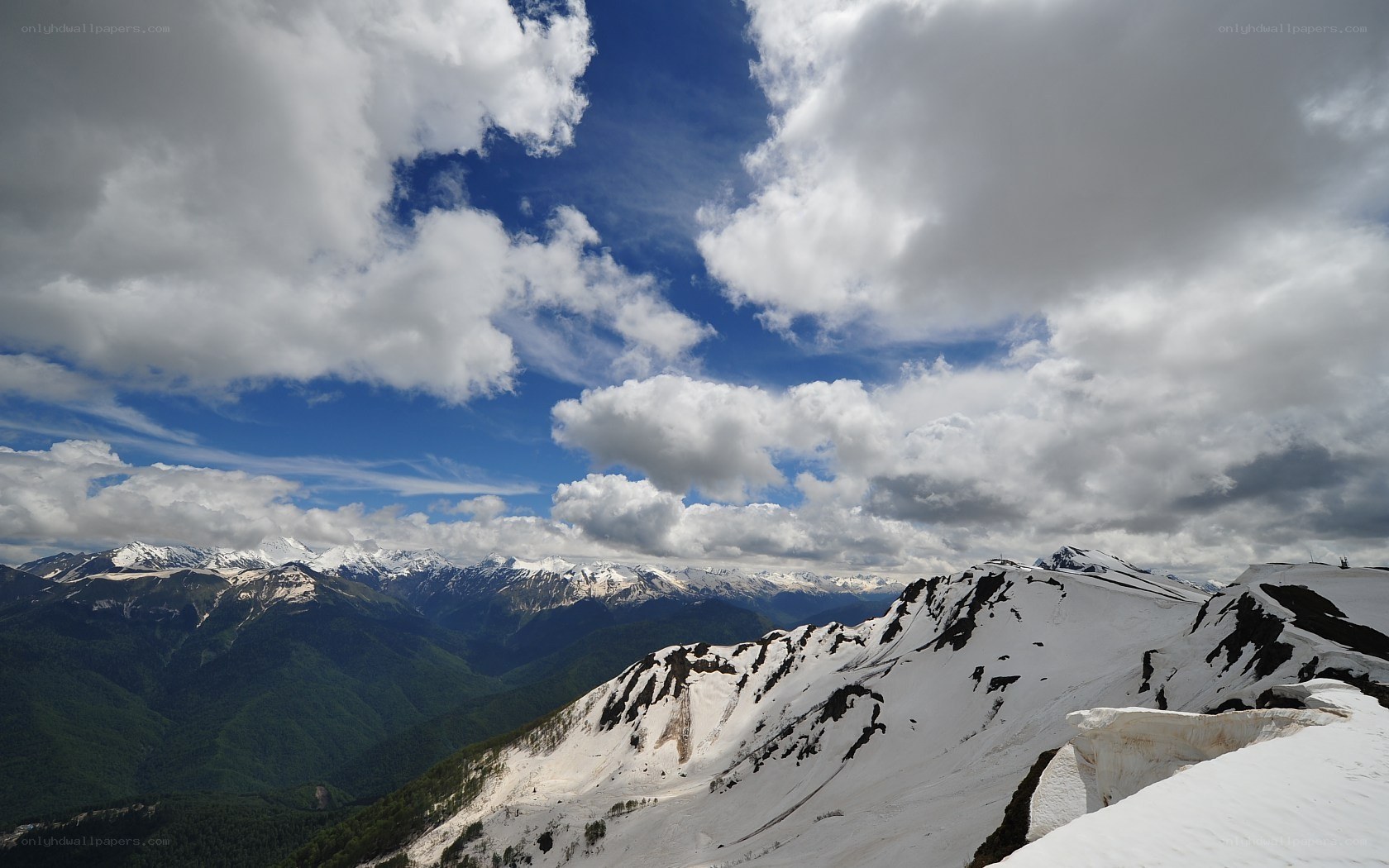 Snowy mountain peaks under cloudy sky