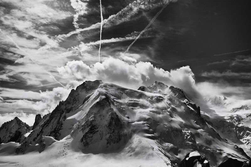 Snowy mountain peaks under cloudy sky
