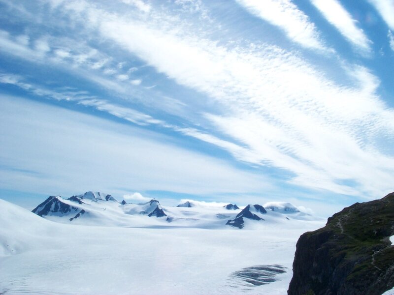 Snowy mountain range under cloudy sky