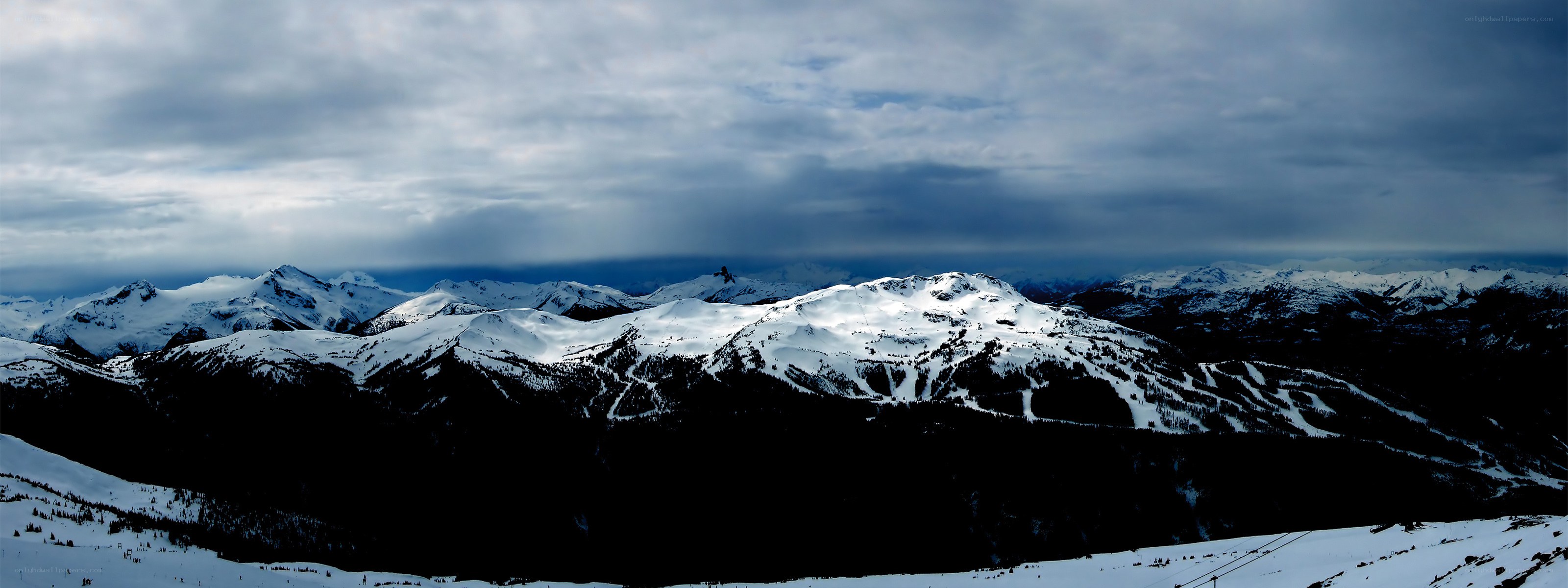 snowy mountain range under cloudy sky