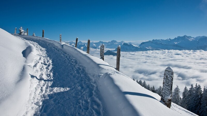 Snowy mountain ridge above clouds