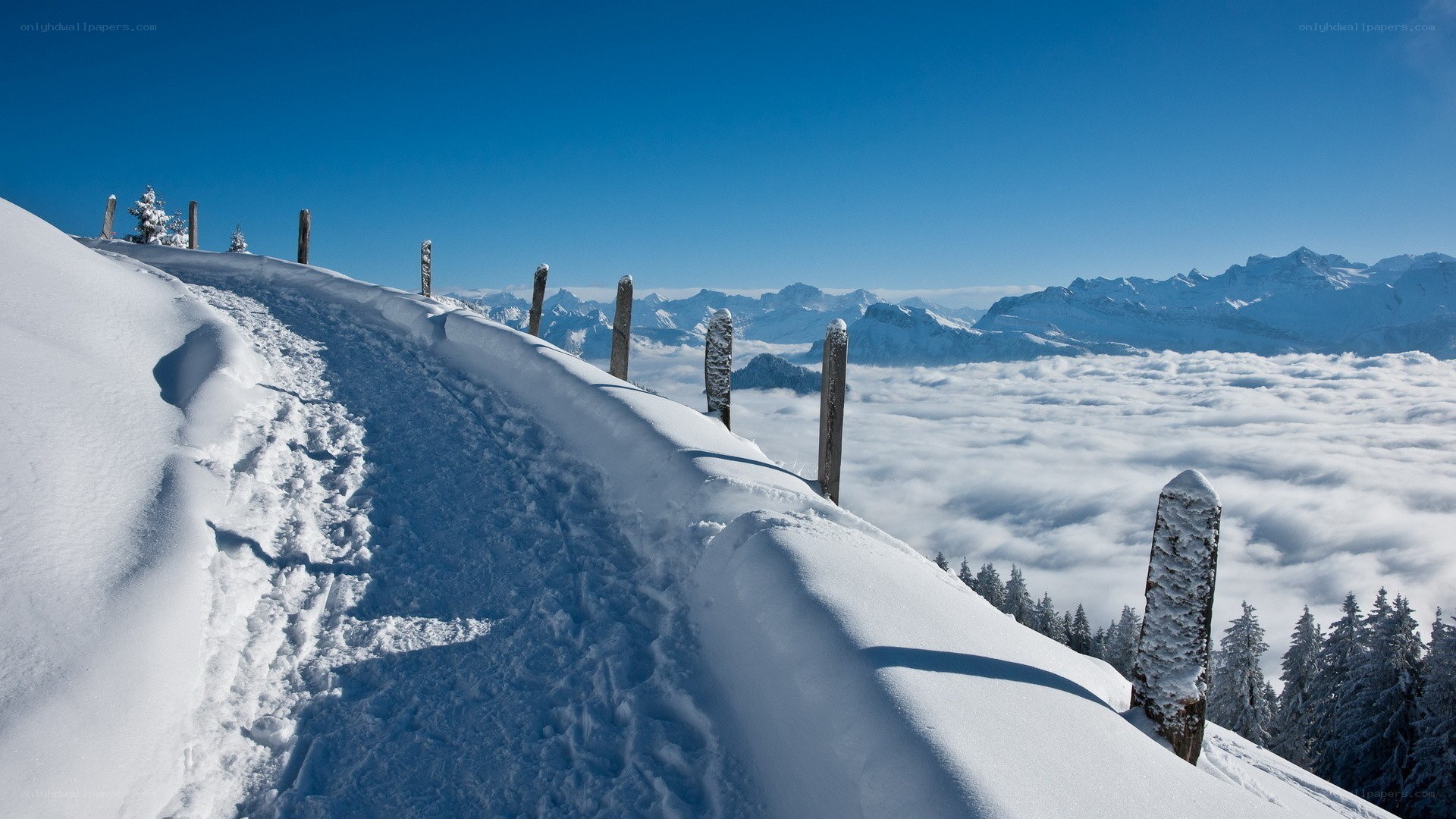 Snowy mountain ridge above clouds