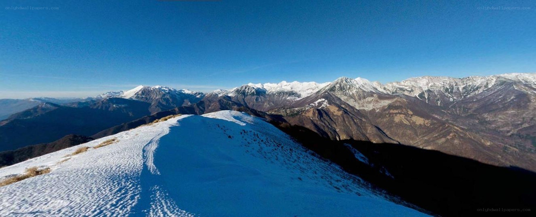 Snowy mountain ridge under blue sky
