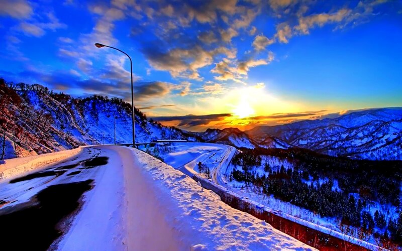 Snowy mountain road at sunset