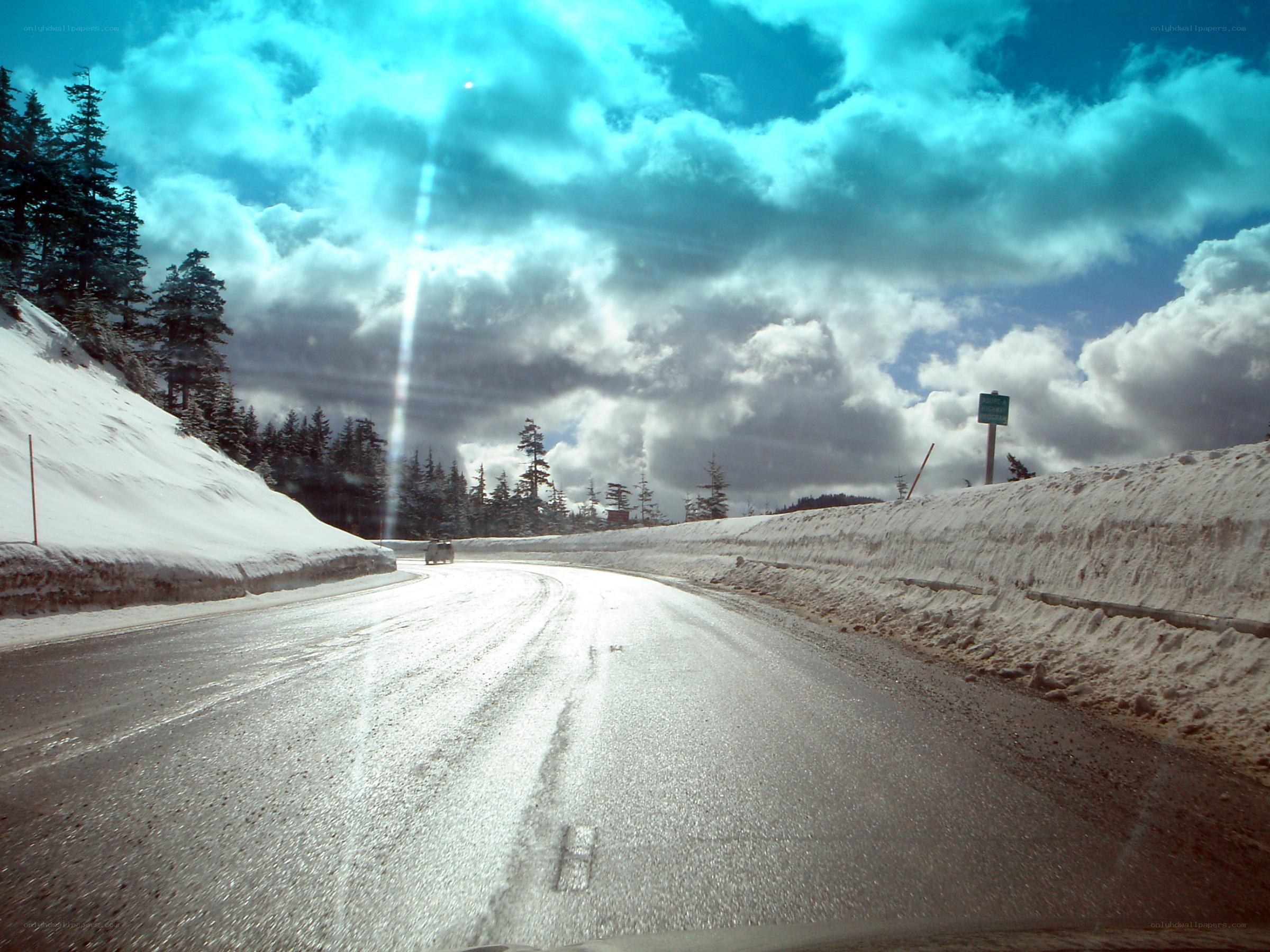 Snowy mountain road with clouds