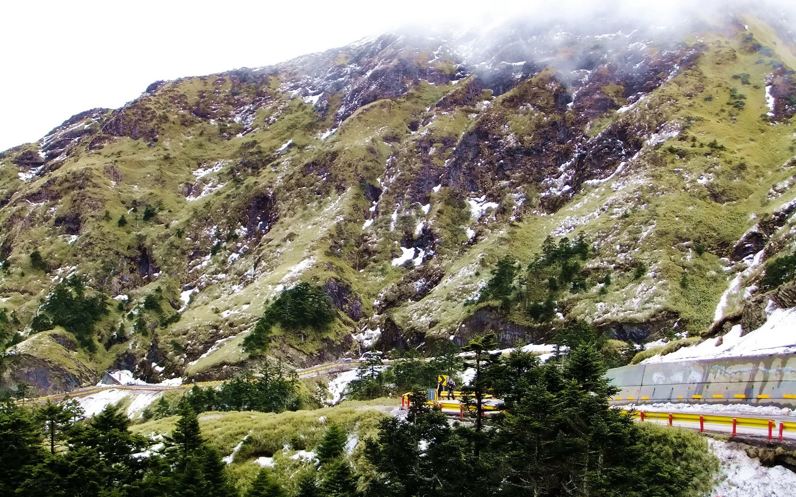 Snowy mountain road with guardrails