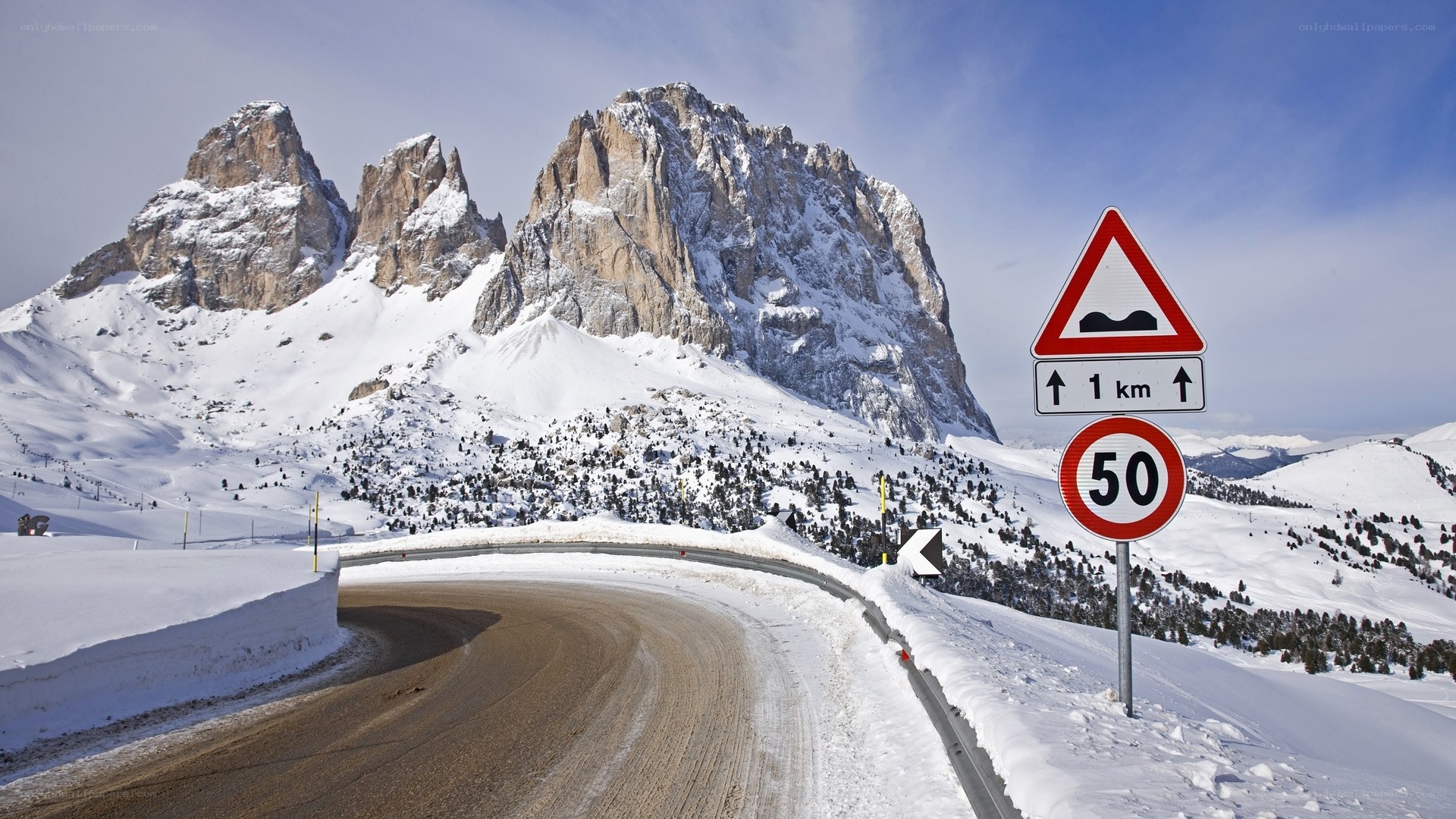 Snowy mountain road with signs
