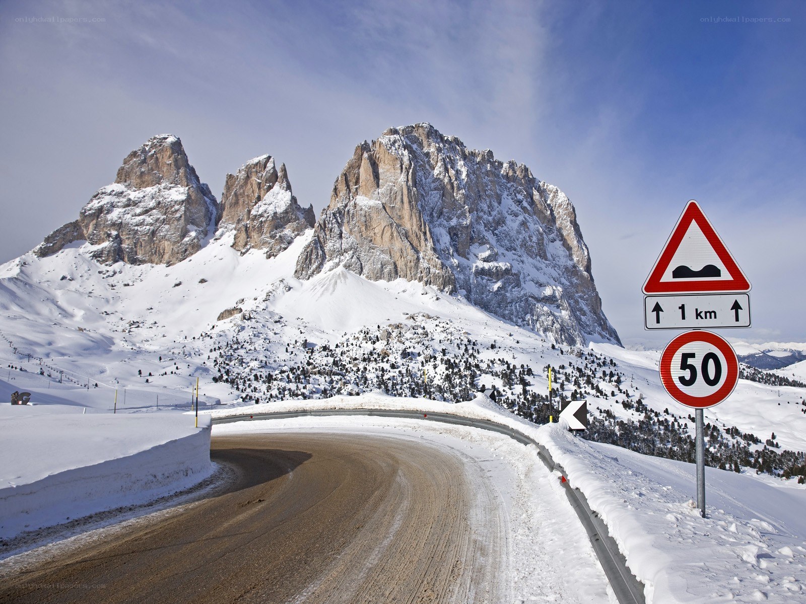 Snowy mountain road with traffic signs