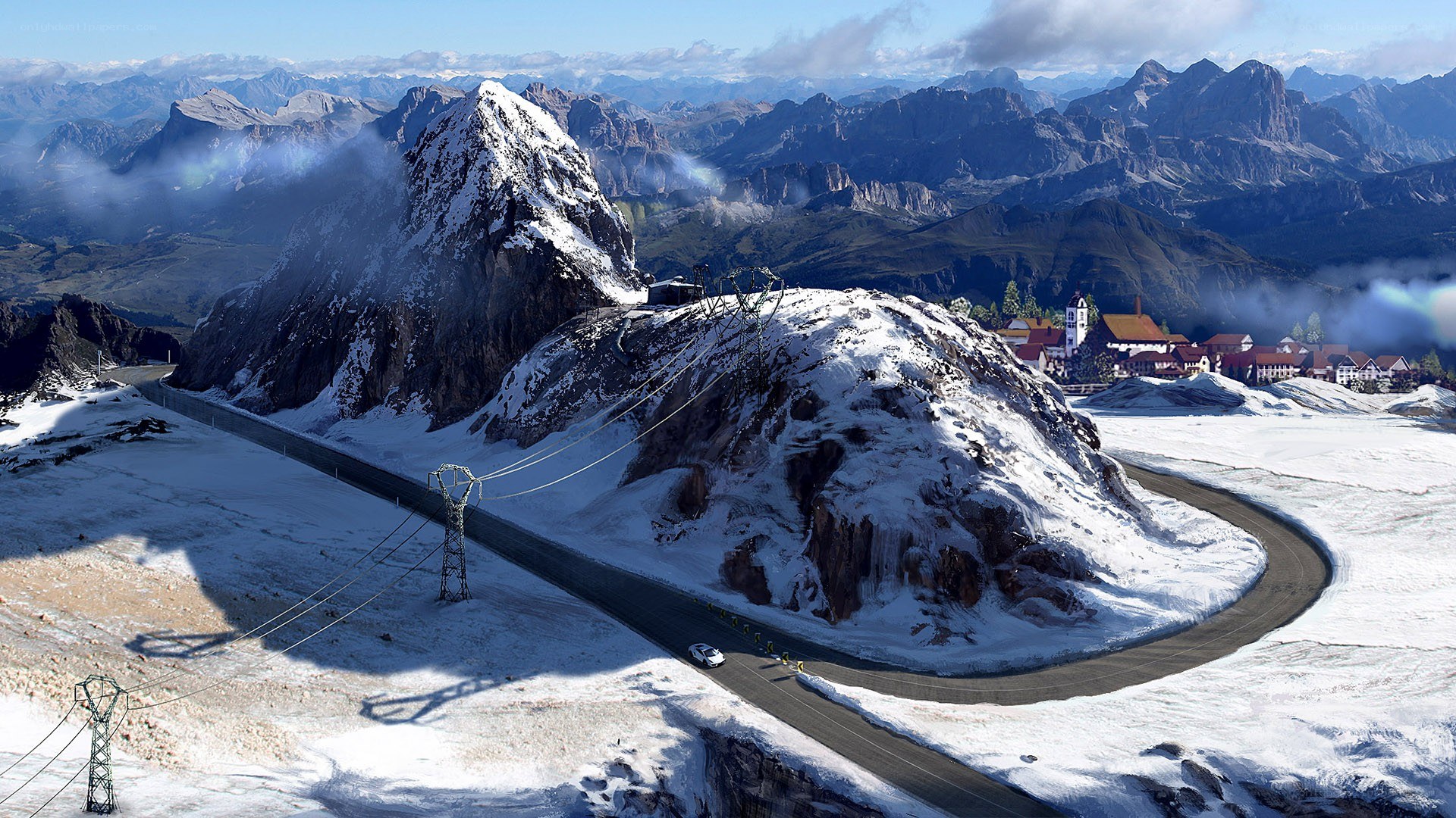 Snowy mountain road with village
