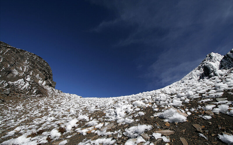 Snowy mountain slope under blue sky