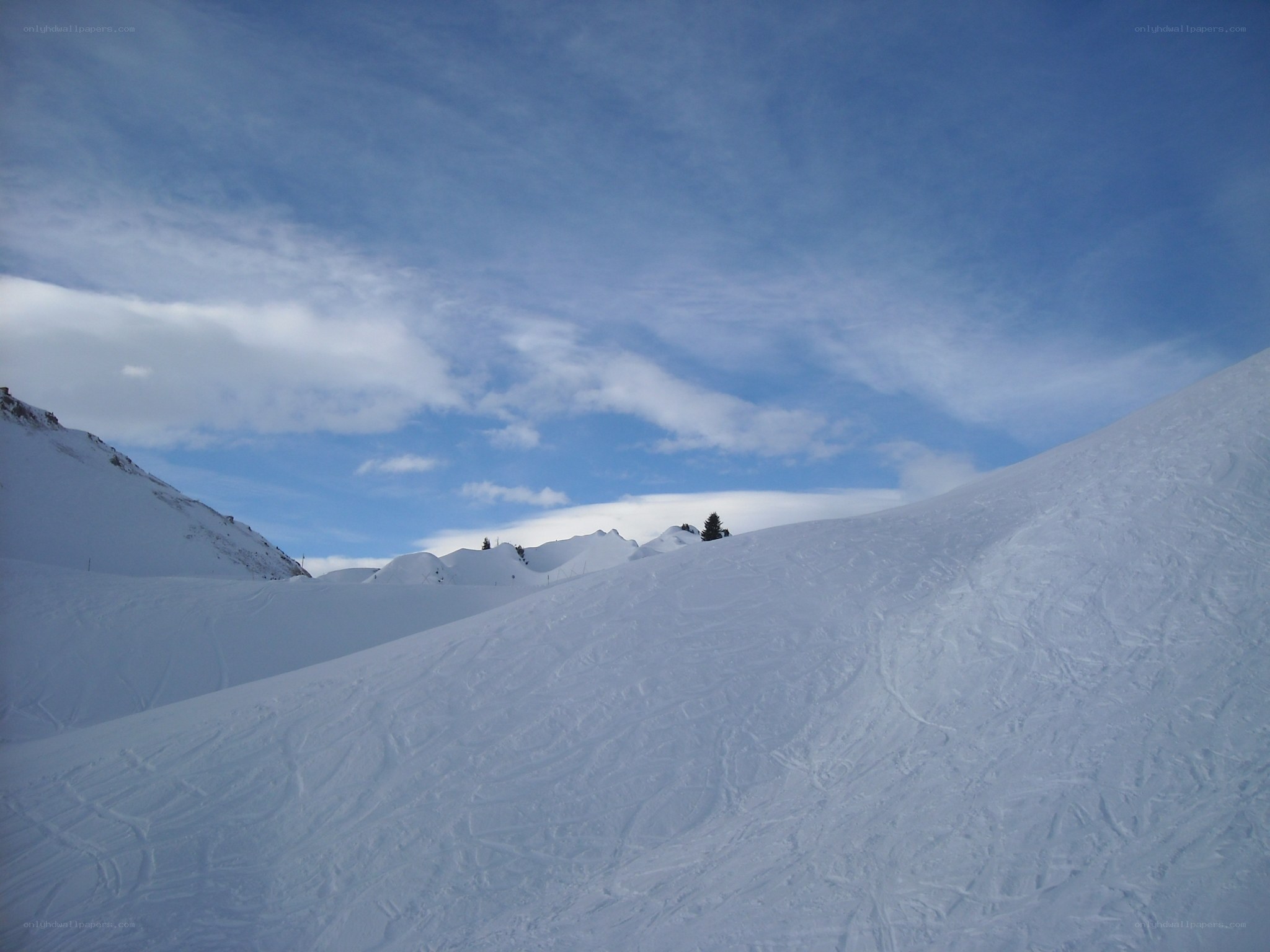 Snowy mountain slope under blue sky