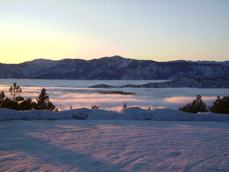 Snowy mountain sunrise with fog