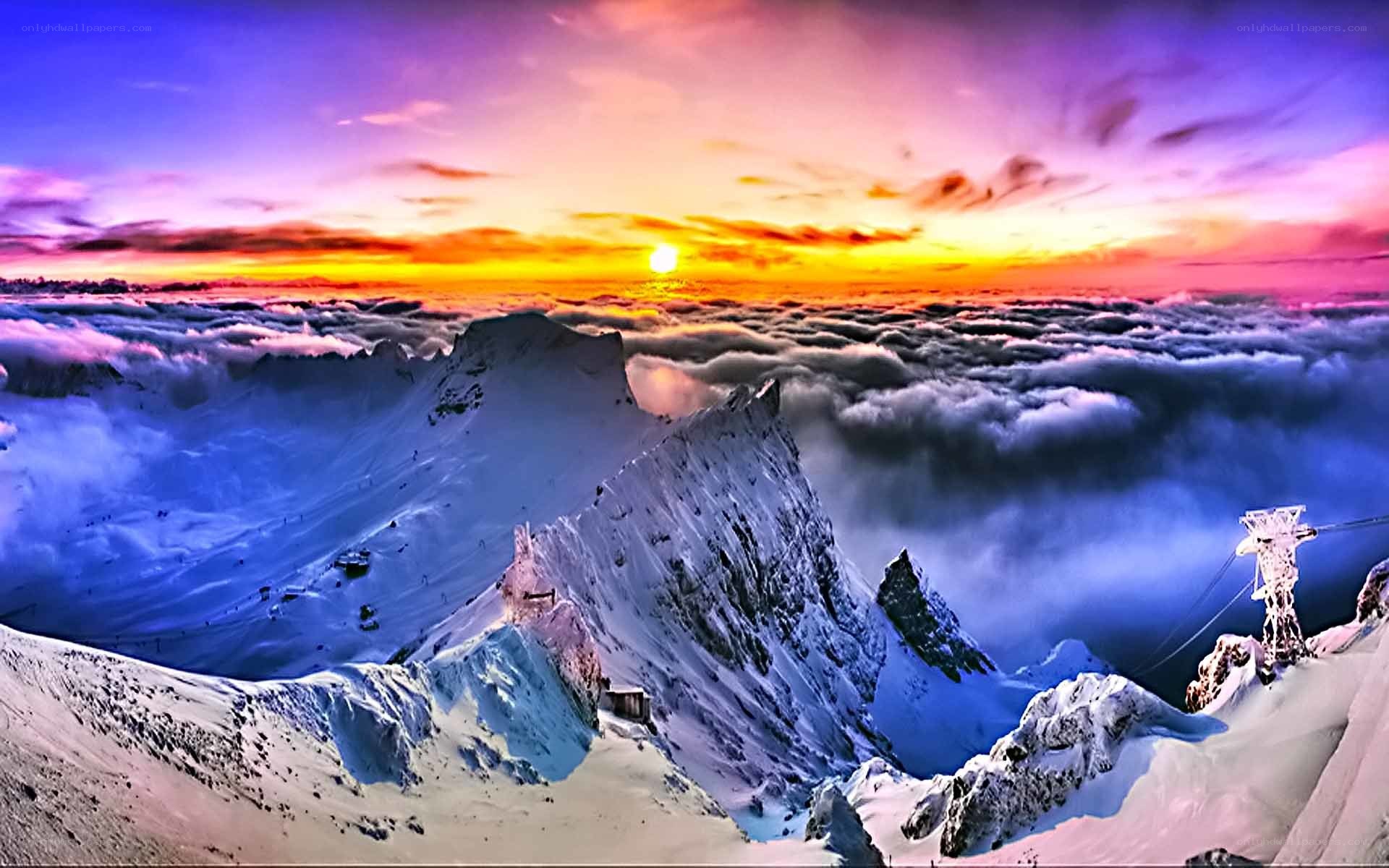 Snowy mountain sunset above clouds