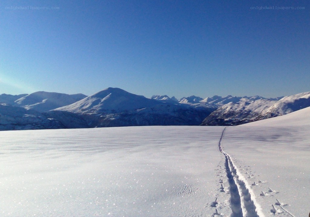 Snowy mountain trail under clear sky