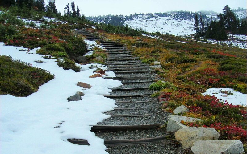 Snowy mountain trail with wooden steps