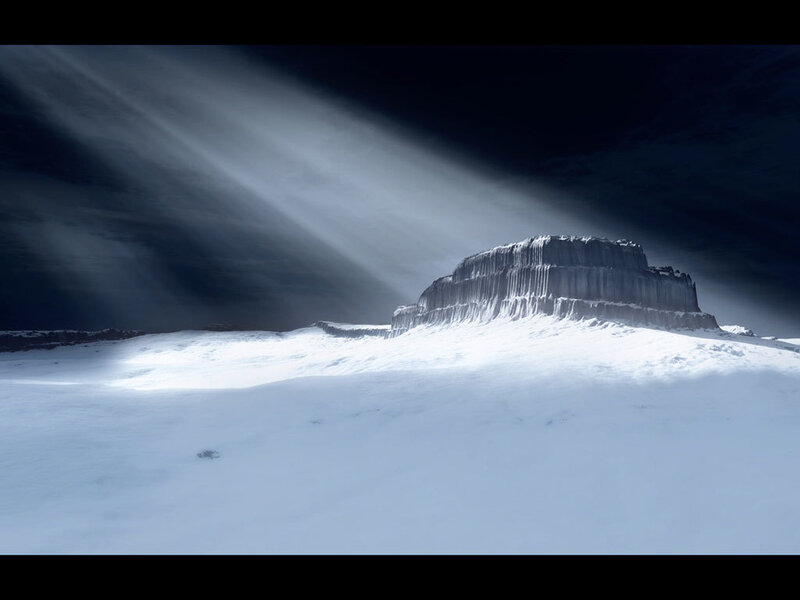 Snowy mountain under beams of light