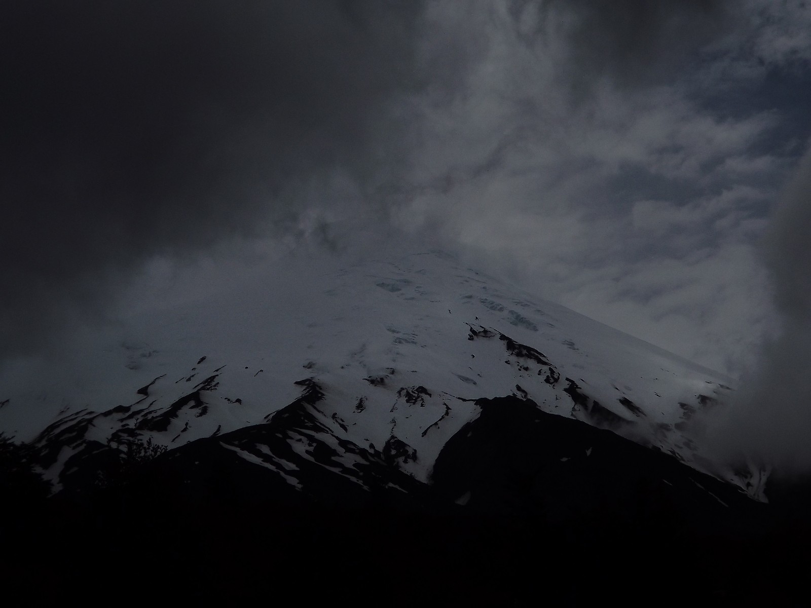 snowy mountain under storm clouds