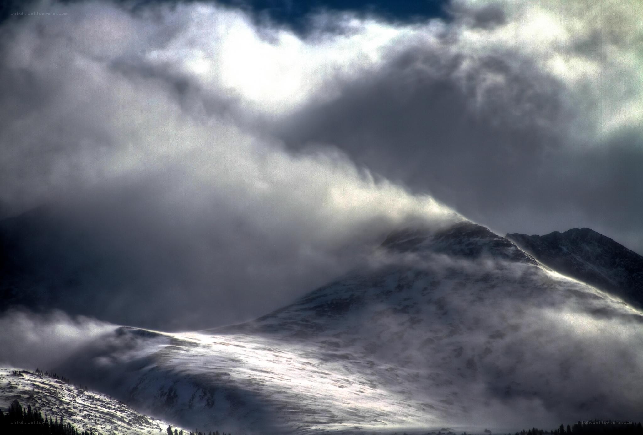 Snowy mountain under storm clouds