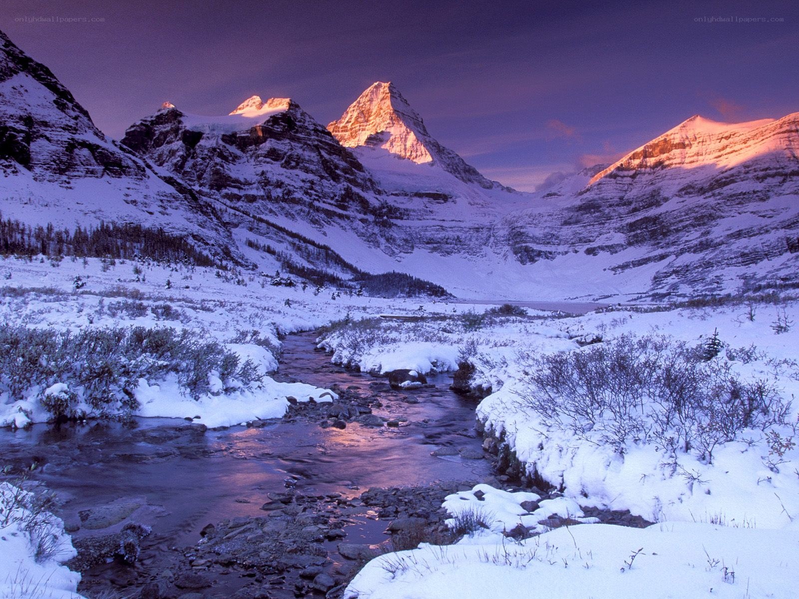 Snowy mountain valley at sunset