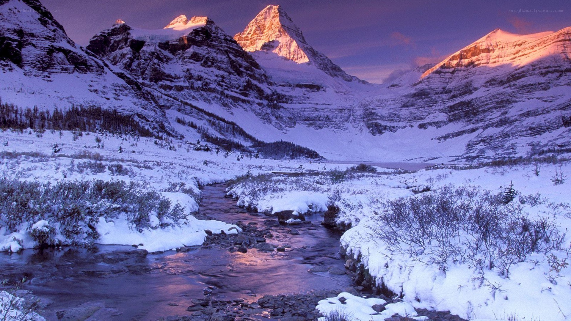 Snowy mountain valley at sunset