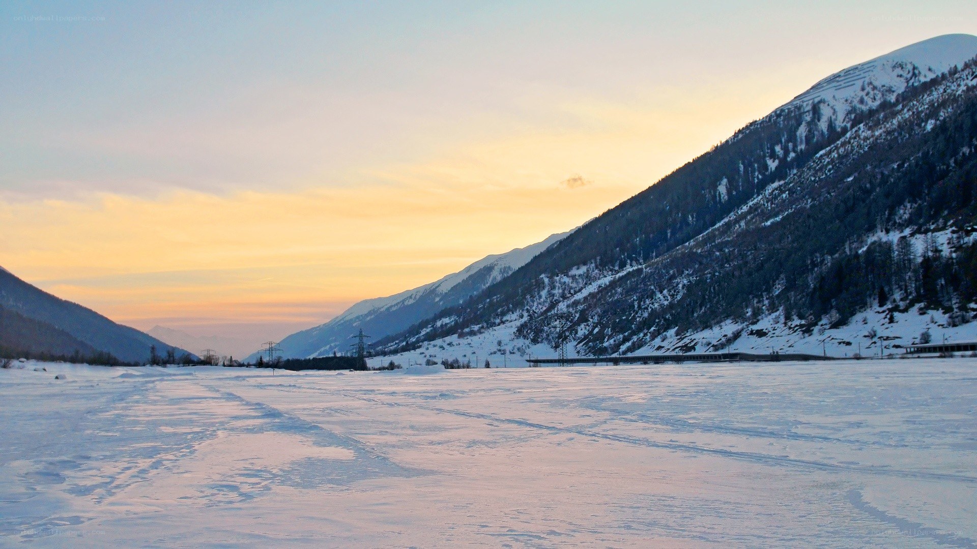 snowy mountain valley at sunset