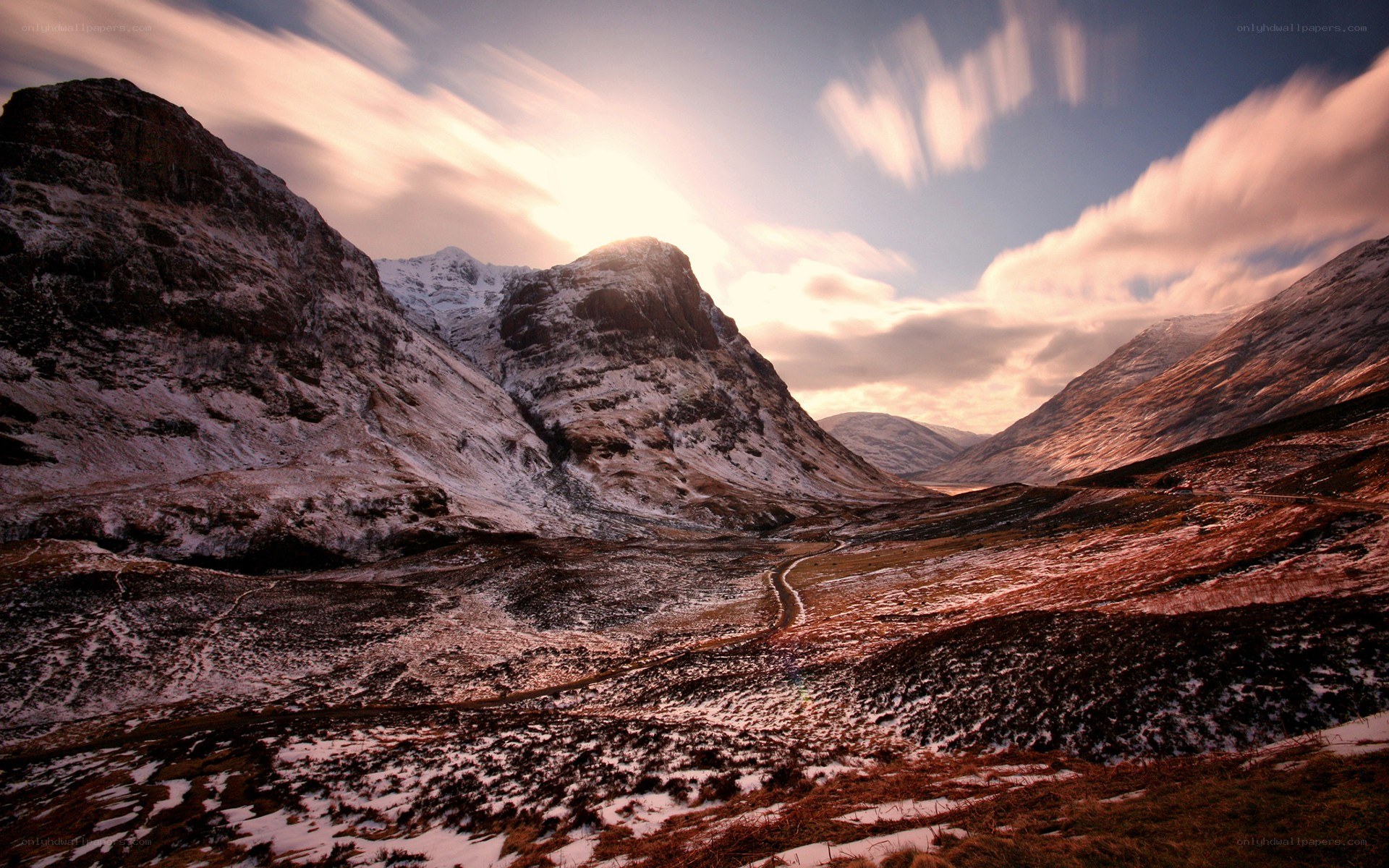 Snowy mountain valley at sunset
