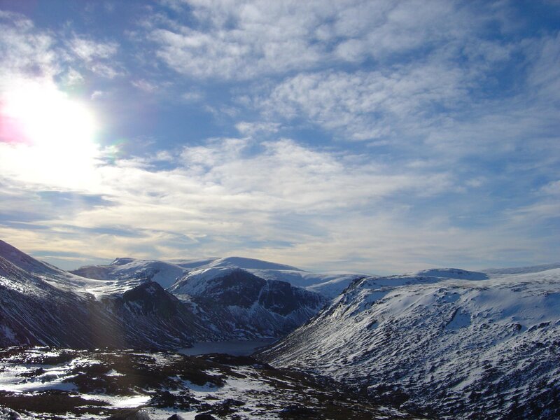 Snowy mountain valley under sunlit sky