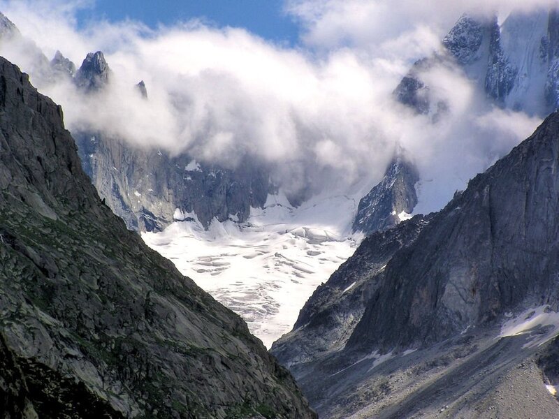 snowy mountain valley with clouds