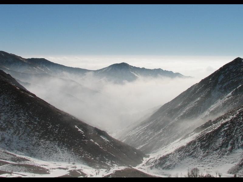 Snowy mountain valley with fog