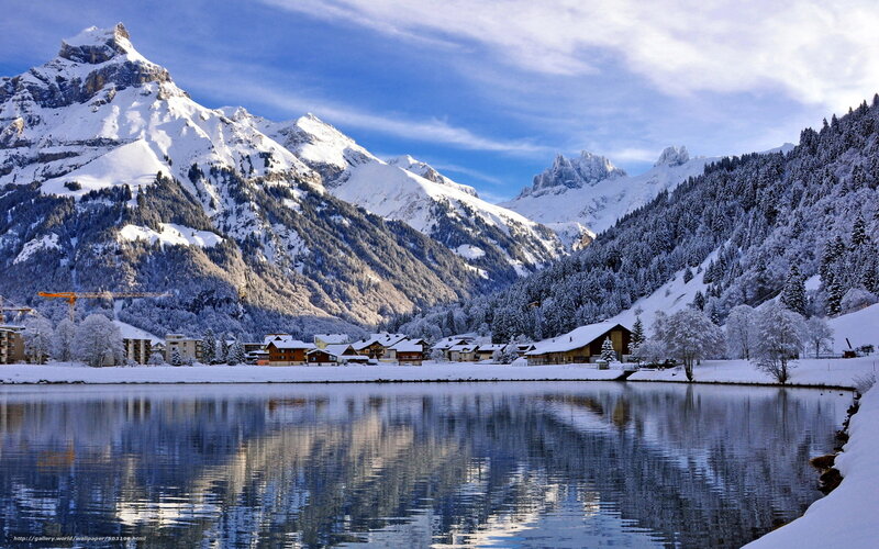 Snowy mountain village by lake