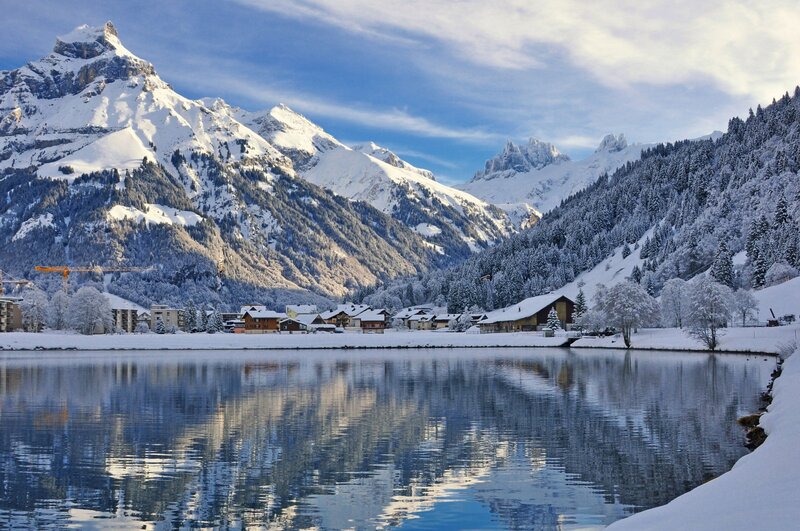 Snowy mountain village by lake