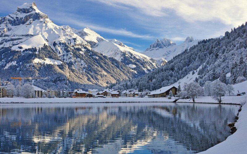 Snowy mountain village by lake