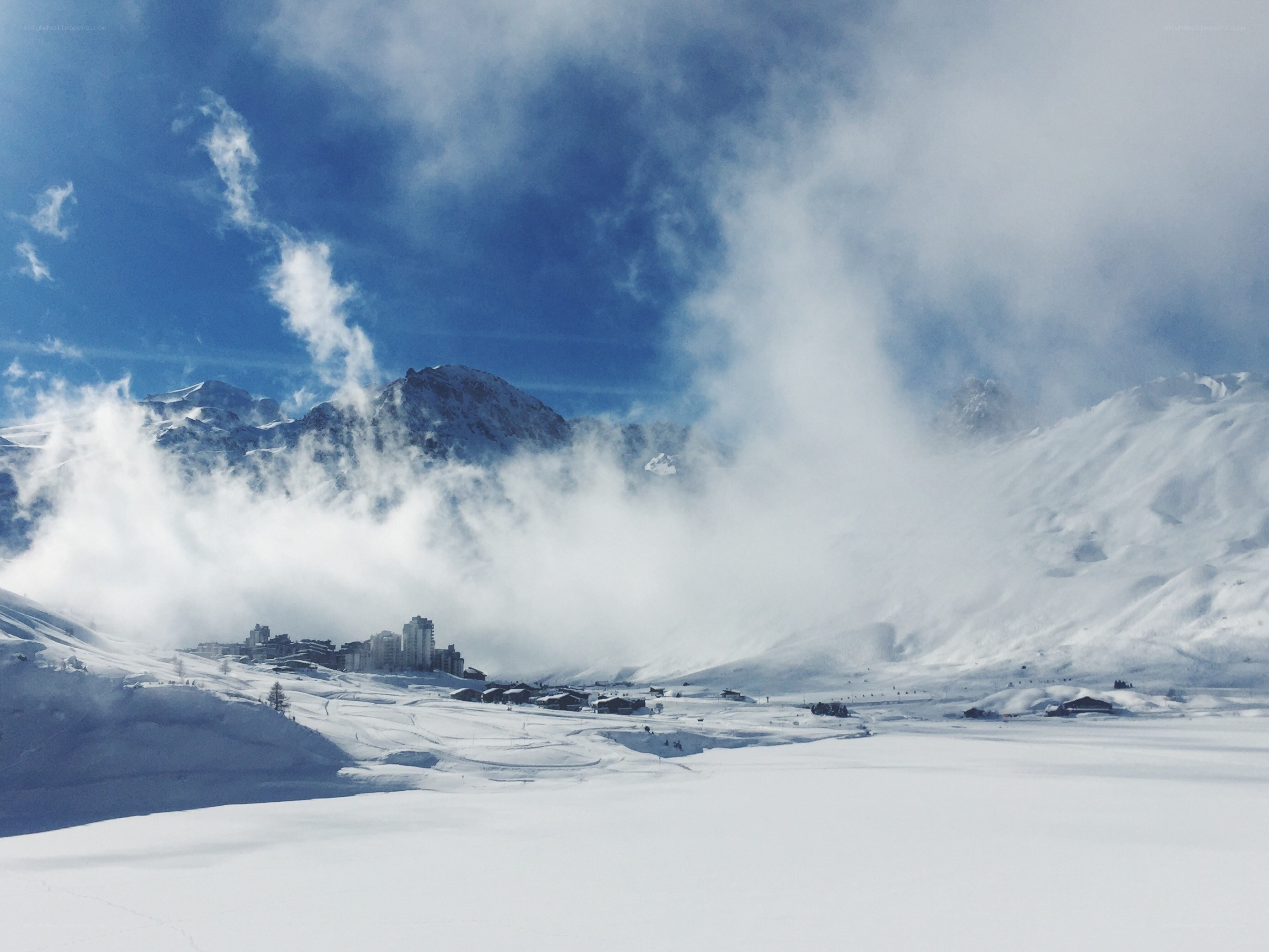 Snowy mountain village under clouds